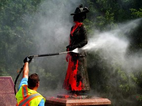 The statue of Emily Murphy at the entrance to Emily Murphy Park in Edmonton is cleaned on Tuesday July 13, 2021 after it was vandalized with red paint.