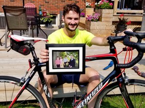 Matthew Vokes with an old family portrait and his bike on Sunday, July 25, 2021. He rode his bike from Toronto to Owen Sound Saturday to mark the 10th anniversary of his father's death. (Scott Dunn/The Sun Times/Postmedia Network)