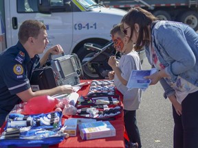 Paramedic Chris Wyshynski shows seven-year-old Drake and his mother Nicole some of the equipment used by EMS on Sat., Sept. 8, 2018. This was the first year that Thank You Day for First Responders was held in conjunction with airdrieFEST. (Photo by Kelsey Yates/Airdrie Echo/Postmedia Network)