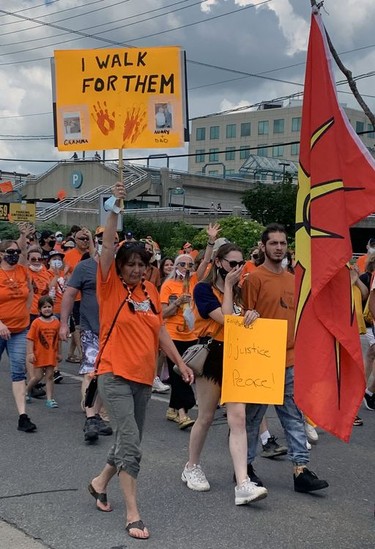 Hundreds of walkers wear orange T-shirts and hold signs to participate in a Unity Walk on Thursday in Brantford from the civic centre to the former Mohawk Institute residential school. Susan Gamble.