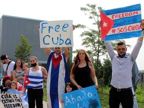 A small group led by Sarah and Miguel Perez, owners of Cuba Fades Barbershop, gather on downtown Colborne Street on Monday morning to show support for the Cuban people. Michelle Ruby