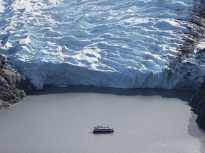 A tour boat is seen near a glacier's terminus in the Kenai Mountains near Primrose, Alaska. Scientists from the U.S. Geological Survey, who have been studying the glaciers in the area since 1966, say their studies show that the warming climate has resulted in sustained glacial mass loss as melting outpaced the accumulation of new snow and ice.