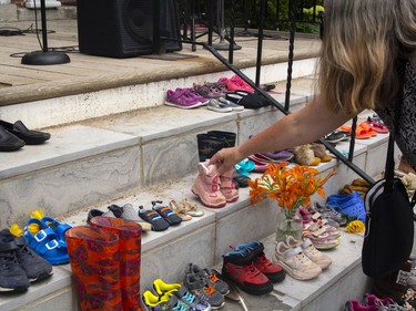 Children's shoes are placed by Indigenous and non-Indigenous people throughout a memorial to remember the lost children from Canadian residential schools. Clarice Gervais says that the shoes help guide the spirits of the children home.