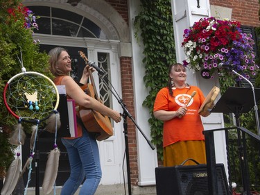 ALPHA band members Angel Kelsey, left, and Donna Lynn Neil perform on the front steps of Gananoque Town Hall on Canada Day in remembrance of the more than 1,100 unmarked gravesites found across Canada. The lost children were remembered by music, singing and shoes left by people along the front steps of the town hall.