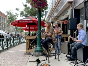 Josee Brault sings on King Street West, accompanied by John Shane, second from left, and James Close Saturday as people enjoy Brockville’s first sidewalk sale since the province started re-opening from the COVID-19 lockdown. (RONALD ZAJAC/The Recorder and Times)