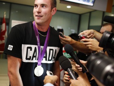 Brockville native Conlin McCabe wears his silver medal as he arrives with other Canadian Olympic team members at the Ottawa International Airport in Aug. 2012.
David Kawai/Postmedia file photo