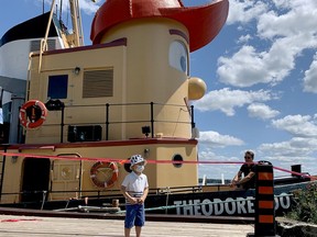 Kaden MacWilliam, 4, of Ottawa, poses for photo by his dad in front of Theodore Too at Centeen Park on Saturday afternoon while deckhand Deven Quantz-Richardson looks on. The chance to pose with the replica of the Theodore Tugboat children's character came a week ahead of even looser COVID-19 restrictions as the area enters Ontario's Step Three. (RONALD ZAJAC/The Recorder and Times)