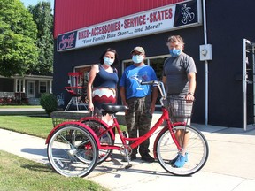 Mike Mariash (left) had tears of joy when he picked up his new tricycle from Smith Cycle, thanks to his friend and co-worker Ashley Tennant rallying the community through a GoFundMe campaign to replace the trike that had been stolen on Mariash's birthday. Rob Smith (right), an employee from Smith Cycle, got the trike assembled for Mariash. Ellwood Shreve/Postmedia Network