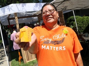 Lana Parenteau, Chatham-Kent's Indigenous peer navigator, shows an example of the orange pins being made to raise donations for local Indigenous organizations. She was at Discover Art Blenheim on Saturday. Mark Malone