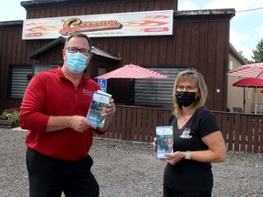 Chatham-Kent Mayor Darrin Canniff, left, delivered copies of the new Chatham-Kent Insider brochure and map to Kim Palin, owner of The Garage Restaurant & Bar, located in Merlin on Friday. Ellwood Shreve/Chatham Daily News/Postmedia Network