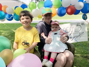 Clayton Nicholson (left), celebrated his 5th birthday in style July 27, as a drive-by thank you was held in his honour as he's considered a hero for being a bone marrow match for his sister Claire (right), who's battling leukemia. Holding Claire is big brother Seth. Clayton said he's looking forward to helping his sister as well as "being knocked out" in hospital when they remove the marrow from his hip. More than 80 vehicles drove by their house to mark his birthday. ANDY BADER/MITCHELL ADVOCATE