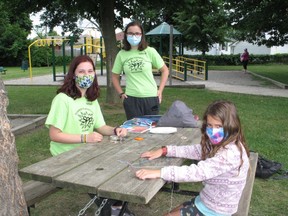 Seven-year-old Maxine Giroux, making bracelets with Summer Playground Program leaders Makena Guindon (left) and Veronique Grigg, at Kinsmen Park. Photo on Wednesday, July 7, 2021, in Cornwall, Ont. Todd Hambleton/Cornwall Standard-Freeholder/Postmedia Network