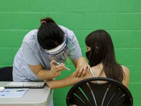 An adolescent receives a dose of the Pfizer-BioNTech Covid-19 vaccine at a clinic in Toronto.