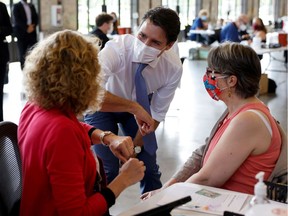 Not quite pressing the flesh: Prime Minister Justin Trudeau bumps elbows with people as he visits a COVID-19 vaccination clinic in Ottawa on July 2.