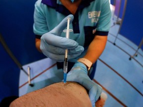 A health care worker administers the Pfizer BioNTech COVID-19 vaccine.
