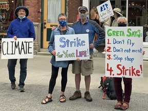 Members of 350 Kingston protest on Princess Street on Friday, July 3, 2021, calling for meaningful and immediate action on climate change.