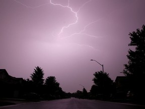 Lightning splits the sky over a darkened Kingston street during a storm Tuesday night that knocked out power to more than 12,000 people in Kingston and the surrounding area, Ont. on Tuesday, July 13, 2021. 
Elliot Ferguson/The Whig-Standard/Postmedia Network