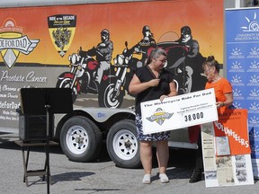 Kingston-Quinte Motorcycle Ride for Dad 2021 chair, Marion Perry, right, presents a grant of $38,000 to the University Hospitals Kingston Foundation and Dr. Katrina Gee, associate professor/researcher, Queen's University School of Medicine, for her work in fighting prostate cancer, at an announcement ceremony outside Cataraqiui Community Centre in Kingston on Friday.