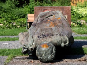 A statue of Queen Elizabeth II is seen overturned and vandalized at the provincial legislature in Winnipeg, Friday, July 2, 2021.