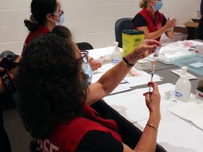 Maureen Church fills a syringe with COVID-19 vaccine at Memorial Gardens. 
Nugget File Photo