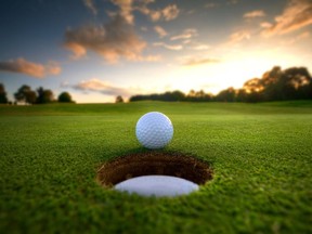 Golf ball about to fall into the cup at sunset.
(Getty images)