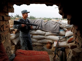 An Afghan policeman keeps watch at the check post on the outskirts of Kabul, Afghanistan, on July 13.