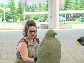 Desiree moulds her eagle sculpture. BOB DAVIES/SAULT THIS WEEK