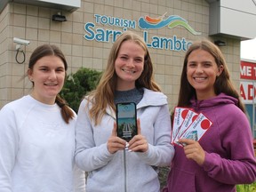 Tourism Sarnia-Lambton summer students, from left, Emma Hendra, Shaelyn Wagenaar and Emma MacLean show a new free Tour Ontario's Blue Coast mobile app and gift certificates rewards users can earn.