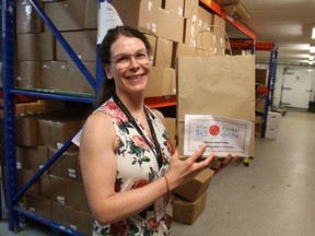 Paul Morden/Sarnia Observer/Postmedia Network Alicia Reny, with the Inn of the Good Shepherd, is pictured in 2019 holding a Snack Pack the Sarnia agency is distributing weekly through the summer to children in low income families to take the place of school nutrition programs. The Snack Packs are distributed as part of the Inn's Mobile Market program.