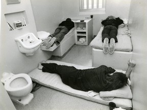 Three inmates at Elgin-Middlesex Detention Centre demonstrate the sleeping arrangement in a cell meant for two, in this file photo from 1988. (London Free Press files)