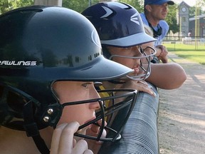 Leah Kelly (left) and Cambell Ward, along with coach AJ Moses, watch the action unfold between visiting Clinton and one of three Mitchell Squirt girls fastpitch softball teams July 26 at Keterson Park in Mitchell. The hometown Hornets dropped a close game, 19-15. ANDY BADER/MITCHELL ADVOCATE
