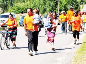 Allison Abitong (right), Michael Eshkawkogan, carrying his son, wife Rachel, carrying her daughter, along with supporters, arrive at the site of former residential schools in Spanish.