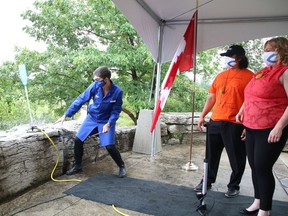Staff scientist Olathe MacIntyre, left, of Science North, releases a water-propelled bottle into the air as Kevin Eshkawkogan, president and CEO of Indigenous Tourism Ontario, and Lisa MacLeod, minister of Heritage, Sport, Tourism and Culture Industries, look on at a funding announcement at the science centre in Sudbury, Ont. on Thursday July 15, 2021. John Lappa/Sudbury Star/Postmedia Network