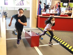 Caitlynn Woo, 11, left, and her sister, Charlotte, 8, race down a sprint track at Science North in Sudbury, Ont. on Friday July 16, 2021. The science centre opened on Friday as part of step three of the Ontario government's reopening plan. Science North is open Thursday to Sunday from 10 a.m. to 4 p.m., while Dynamic Earth is open Saturday to Tuesday from 10 a.m. to 4 p.m. John Lappa/Sudbury Star/Postmedia Network