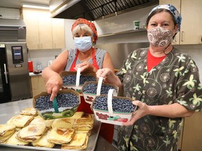 Daria Zelenczuk, left, and Linda Russell, of the Ukrainian Seniors' Centre in Sudbury, Ont., prepare food items for a luncheon featuring blueberries on Thursday July 22, 2021. The menu includes nalysnyky (crepes) with a cottage cheese mixture and blueberry sauce, a hot lunch featuring pyrohy, cabbage rolls and oven roasted chicken, blueberry tarts and blueberry pyrohy, or fresh cabbage rolls and pyrohy. Orders can be picked up curbside from 11 a.m. to 1:30 p.m. at the centre at 30 Notre Dame Ave. Orders must be placed by July 21 by calling 705-673-7404. The Ukrainian Seniors' Centre recently made a $2,500 donation to the Maison McCulloch Hospice through the hospice's care-a-thon, thanks to the centre's previous fundraising efforts. John Lappa/Sudbury Star/Postmedia Network
