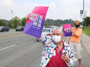 Health Sciences North employee Monique Berthiaume, front, and Nickel Belt MPP France Gelinas take part in a rally near the Paris Street entrance to HSN in Sudbury, Ont. on Thursday July 29, 2021. John Lappa/Sudbury Star/Postmedia Network