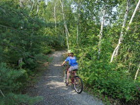 Arik Kabaroff-Scott bikes on the trails in the Laurentian University greenspace.