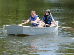 Dominic Paton (left) and Carter Humeniuk row the boat they helped build at the Upper Deck Youth Centre on Lake Lisgar Saturday. (Chris Abbott/Norfolk and Tillsonburg News)