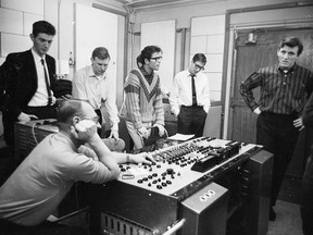 Cliff Richard (aka Harry Webb) in a stylish sweater, listens as the producer and recording technician makes some adjustments in a recording studio of EMI in London, in this photo from Nov. 19, 1962. Second from right is Hank Marvin (aka Brian Rankin) and on the right in striped shirt, Bruce Welch, both of the backing group the Shadows. Getty Images ORG XMIT: POS2020091607133168923248071