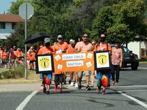 Walkers head down Valley Drive in Kenora on their way to the former site of the Cecilia Jeffrey Indian Residential School on Thursday, July 1.