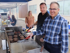 Volunteer Rob Pastoor, left, and board member Ray Hilts grilled burgers for the annual barbecue fundraiser for Tennille's Hope Soup Kitchen Thursday. The event raised $856.75 to support daily operations and for foods.