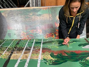 Burk's Falls artist Haleigh Lawrence works on one of the many boards she has been painting that will eventually form a 12-foot high, 64-foot long mural. The artwork, which showcases various Burk's Falls images, will line the side of the village's latest business, The Emporium. Riverbowl of Burk's Falls Photo