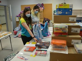 United Way of Bruce Grey Backpack Program Co-ordinator Jasmine Adams, right, and her sister Trinity Adams, fill backpacks with supplies at the Sydenham Campus in Owen Sound on Friday, August 6, 2021.