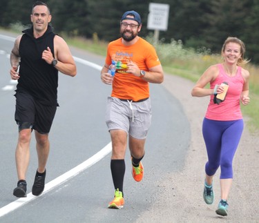 Sonny Spina (left) and Theresa Mudge help Rick Fall wrap up his cross-country run on Saturday, Aug. 7, 2021 in Sault Ste. Marie, Ont. (BRIAN KELLY/THE SAULT STAR/POSTMEDIA NETWORK)