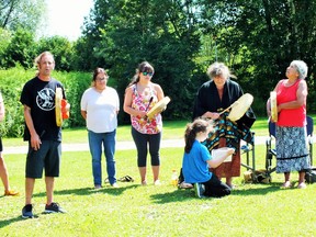 Singers and drummer offer prayer and honour song welcoming paddlers at Residential school site. From left to right: Steven Baranyai, Amanda Medahbie, Cathy Commanda, Joyce Dillen, Gail Jacobs