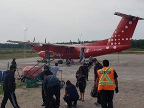Evacuees from Pikangikum First Nation arrive back in their home community from Sudbury.