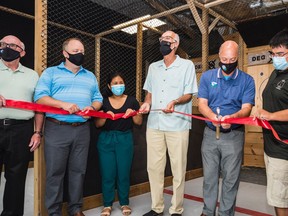 Joel George, right, owner of Ded Eye Axe Throwing, is joined by local leaders as Belleville Mayor Mitch Panciuk cuts a red ribbon with an axe Friday officially opening the axe throwing venue in Belleville, Ontario. ALEX FILIPE