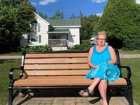 Jackie James sits on her son's memorial bench Friday. The Callander resident is upset someone took the flowers she planted honouring her son who died on May 31, 2015.