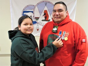 Sgt. Matthew Gull, commander of the Canadian Ranger patrol in Peawanuck, has his youngest daughter Amelia put an Order of Military Merit insignia on his uniform as part of a unique military ceremony in Timmins recently. SUBMITTED PHOTO
