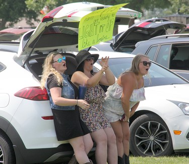 A trio of music fans whoop it up from their car at an outdoor drive-in concert featuring Lemon Cash and River Town Saints held in Pembroke's Riverside Park on Saturday, Aug. 7.